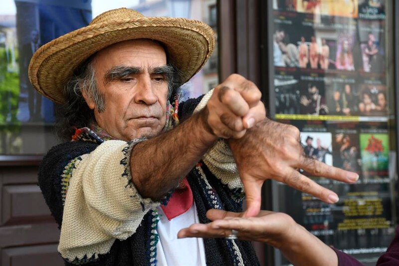 Un hombre con sombrero de paja hace un gesto con las manos