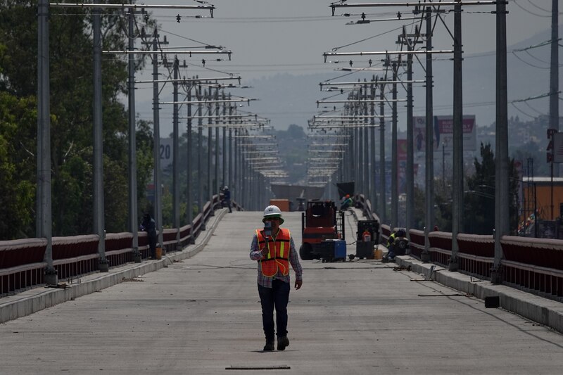 Un trabajador de la construcción camina por un puente en construcción