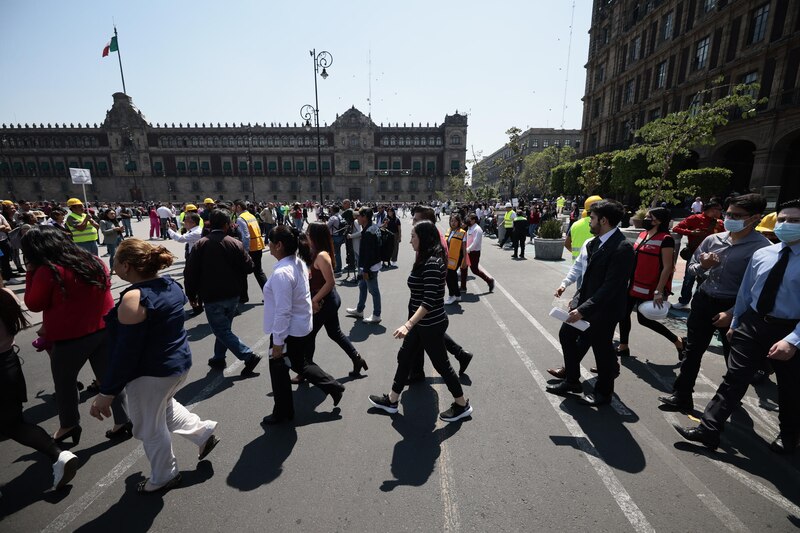 Multitud de personas caminando por una calle en el zócalo de la Ciudad de México