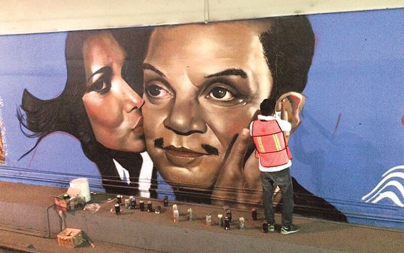 Artista urbano pinta un mural en la calle