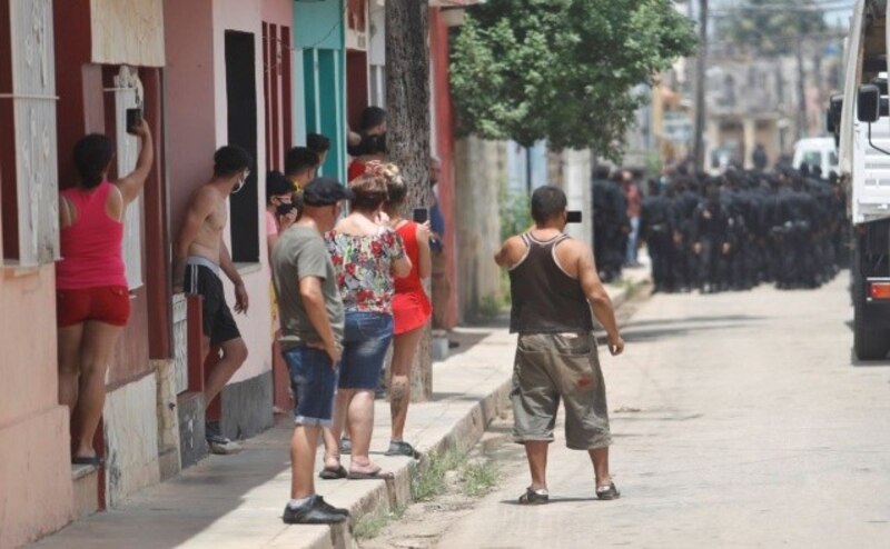 La policía detiene a un grupo de personas en una redada.