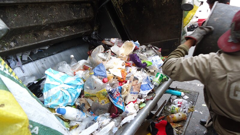 Un camión de basura se lleva la basura de la calle