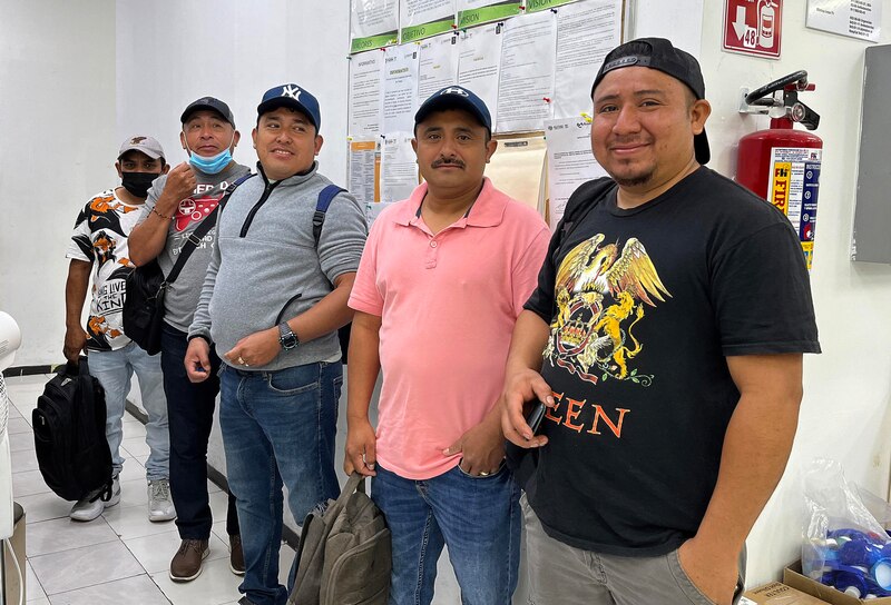 Cuatro hombres sonríen a la cámara.