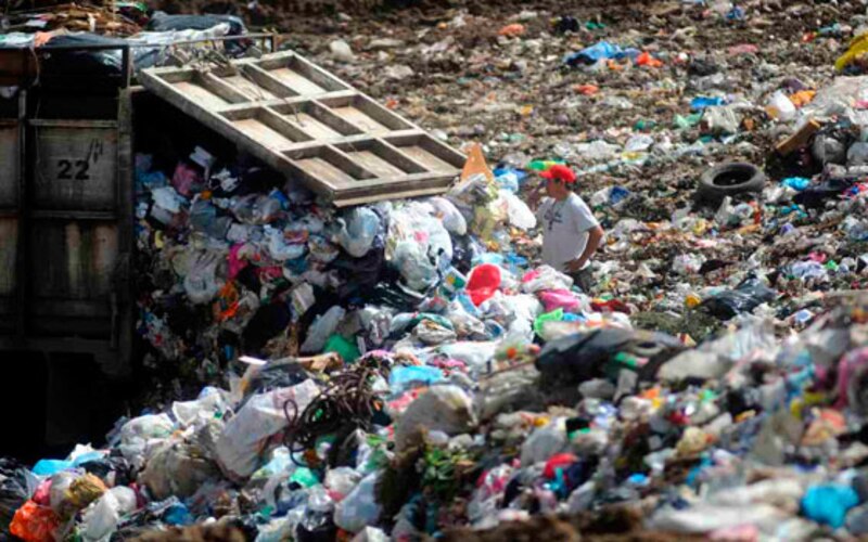 Un camión de basura vierte su carga en un vertedero