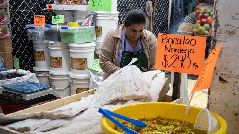 Mujer vendiendo bacalao noruego en un mercado