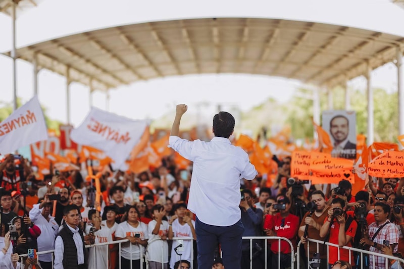 Un político da un discurso ante una multitud.