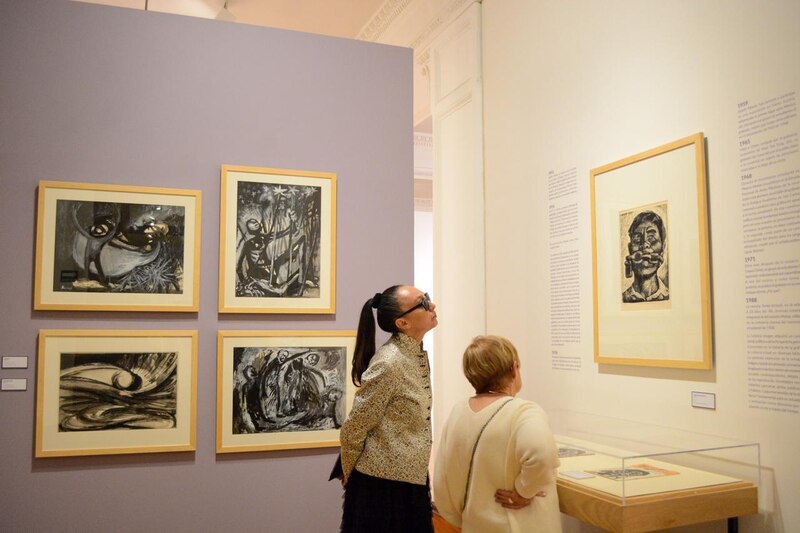 Mujeres observando pinturas en un museo