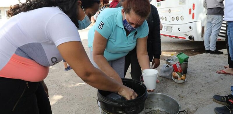 Mujeres preparando comida en una olla grande