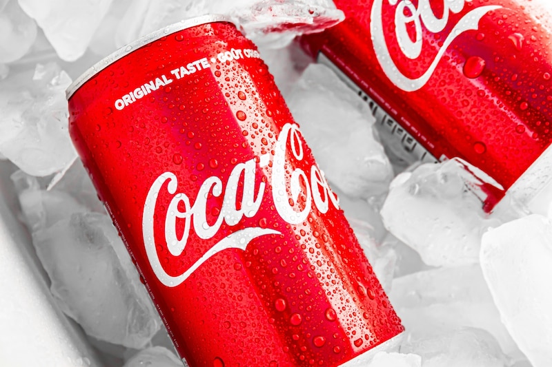 Dos latas de Coca Cola sobre hielos