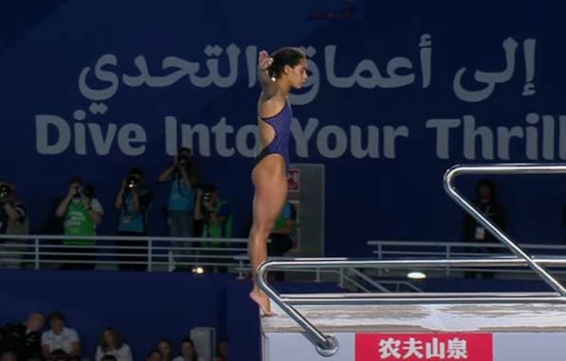 Clavadista femenina en posición de salto.