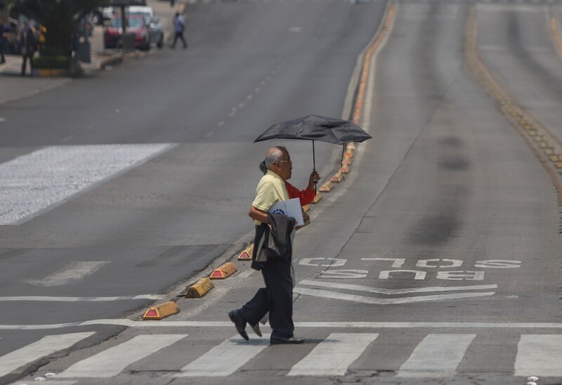 Un hombre camina por un paso de peatones en una calle de la Ciudad de México