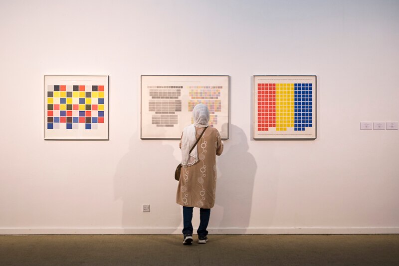 Mujer mirando cuadros en una galería de arte