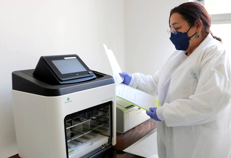Científica en un laboratorio utilizando una máquina para realizar pruebas de ADN