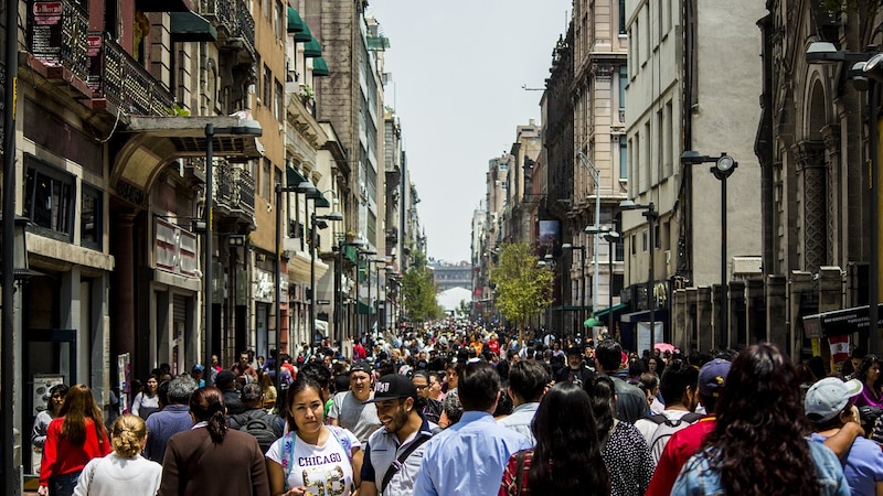 Multitud de personas caminando por una calle en el centro de la ciudad.