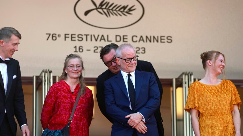 El director Ruben Östlund, la actriz Charlbi Dean y el actor Woody Harrelson en la alfombra roja del 76º Festival de Cine de Cannes.