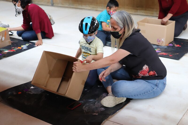 Niños aprendiendo a hacer manualidades con cajas de cartón