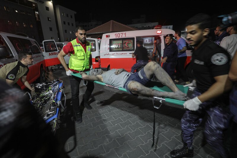 Rescatistas llevan a un herido en camilla tras un ataque aéreo en Gaza