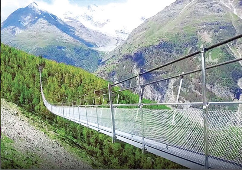 Puente colgante sobre un valle alpino