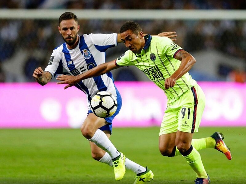 Dos jugadores de fútbol disputan un balón dividido.