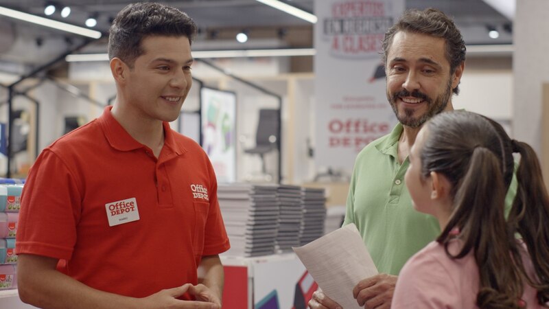 Empleado de Office Depot ayuda a un padre y a su hija a elegir los útiles escolares