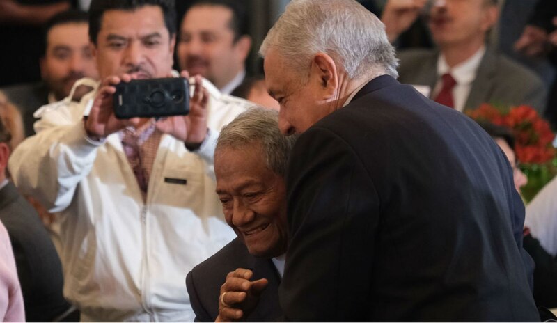 El presidente López Obrador abraza a un hombre en silla de ruedas