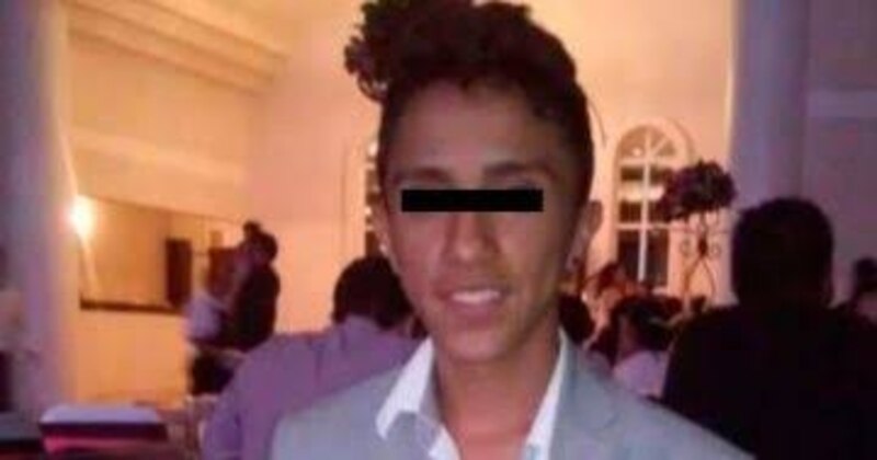 Joven hispano con traje gris sonríe a la cámara