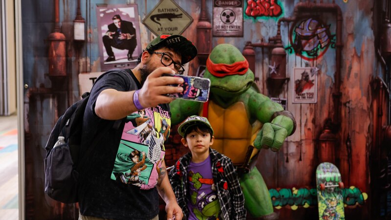 ¡Un padre y su hijo se toman una foto con una estatua de Michelangelo de las Tortugas Ninja!