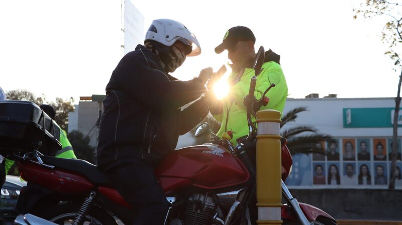 Un motociclista es detenido por un policía de tránsito.