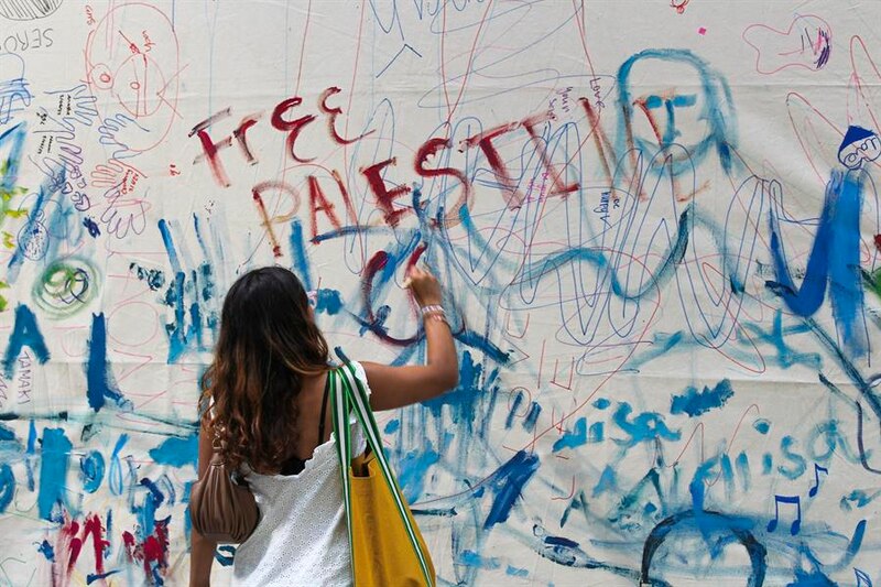 Mujer escribe graffiti en una pared