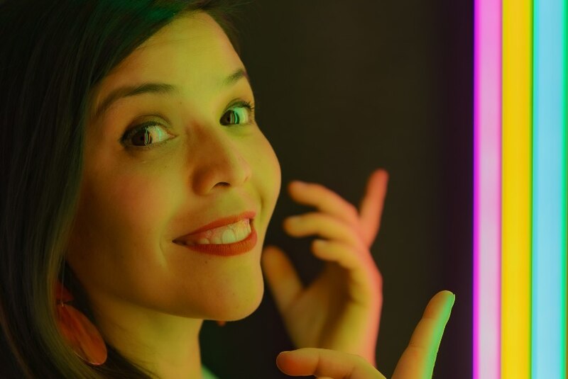 Mujer joven con luces de neón de colores.