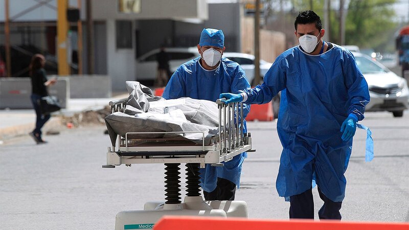 Personal médico traslada el cuerpo de una víctima de COVID-19