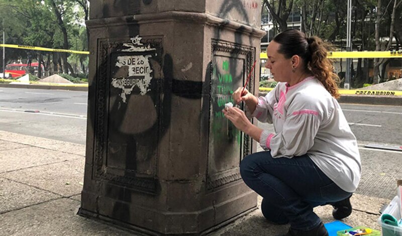Artista pinta un mural en una calle de la Ciudad de México