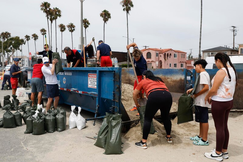 Voluntarios llenan costales de arena para proteger la ciudad de una tormenta