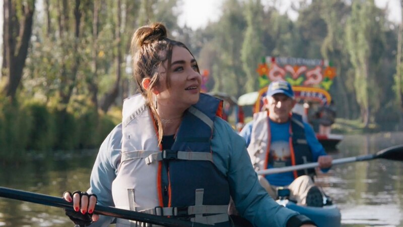 Mujer joven remando en kayak en un río.