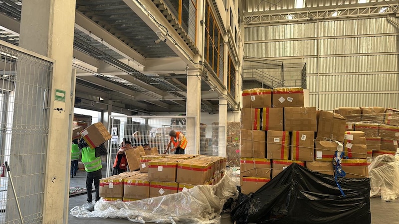 Trabajadores en un almacén cargando cajas en una plataforma