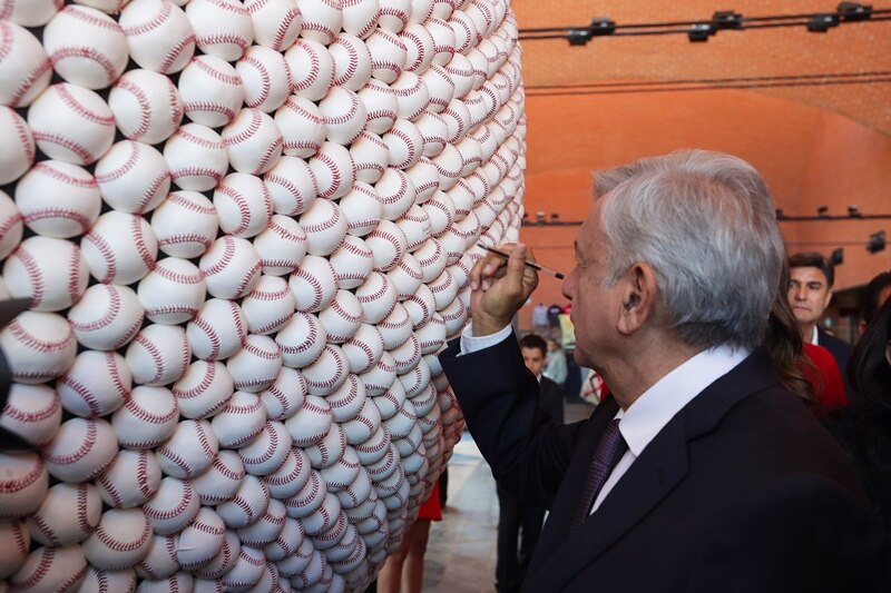 El presidente López Obrador firma pelotas de béisbol en el Museo del Salón de la Fama