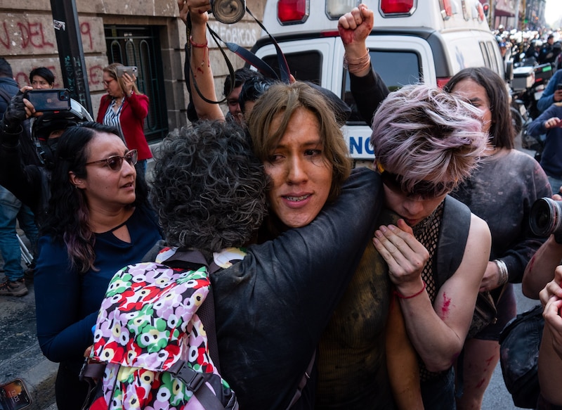 Mujeres se abrazan en una protesta