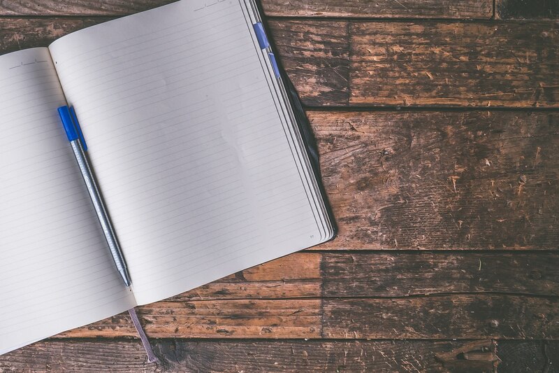 Cuaderno y bolígrafo sobre una mesa de madera