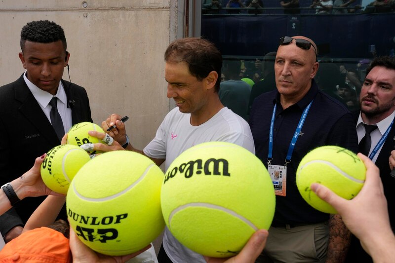 Rafael Nadal firma pelotas de tenis para sus fans