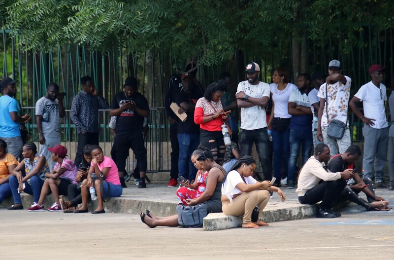 Migrantes hacen fila en espera de resolver su situación migratoria en el municipio de Tapachula