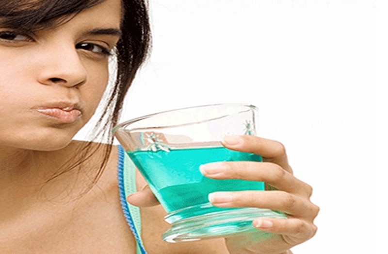 Mujer usando enjuague bucal