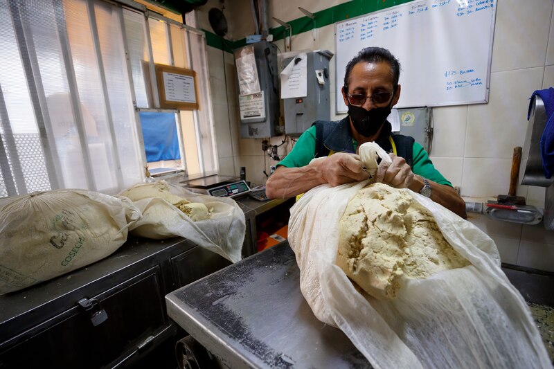 Un hombre preparando masa de maíz