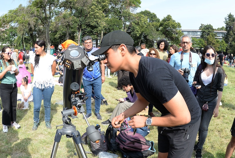 Un joven mira a través de un telescopio