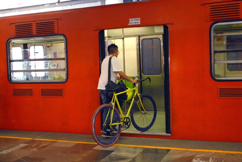Un hombre espera el metro con su bicicleta