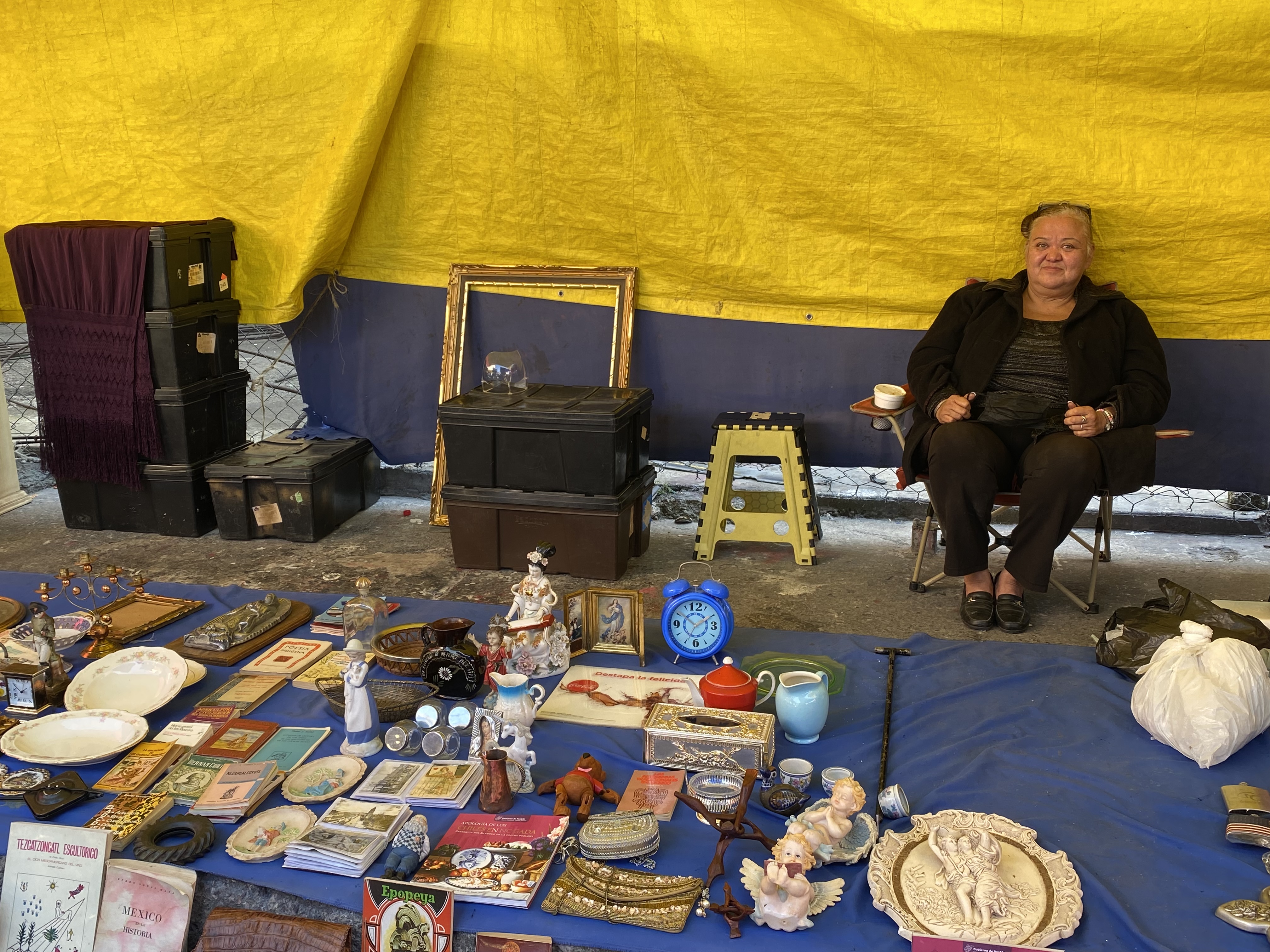 Una mujer vende antigüedades en un mercado de pulgas.