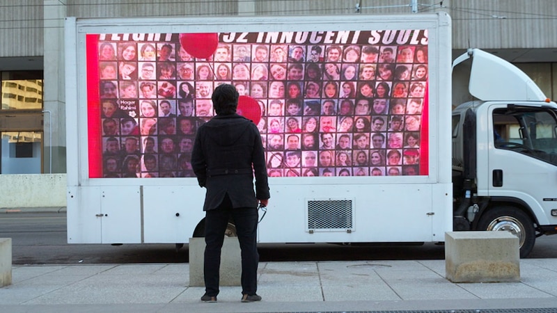 Un hombre mirando una pantalla con muchas caras