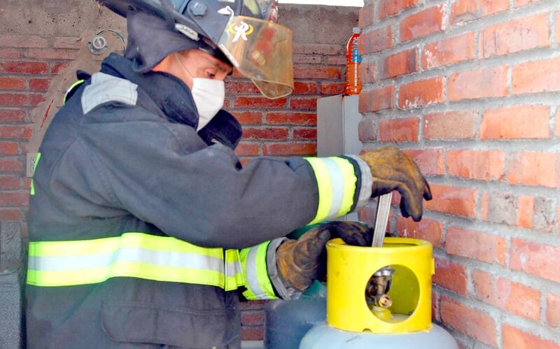 Bombero apaga incendio en garrafa de gas