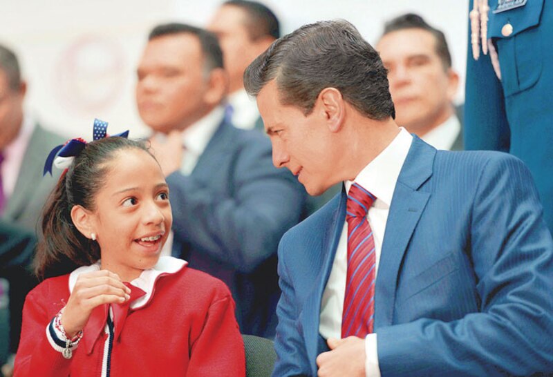 El presidente Enrique Peña Nieto convive con una niña durante un evento público.
