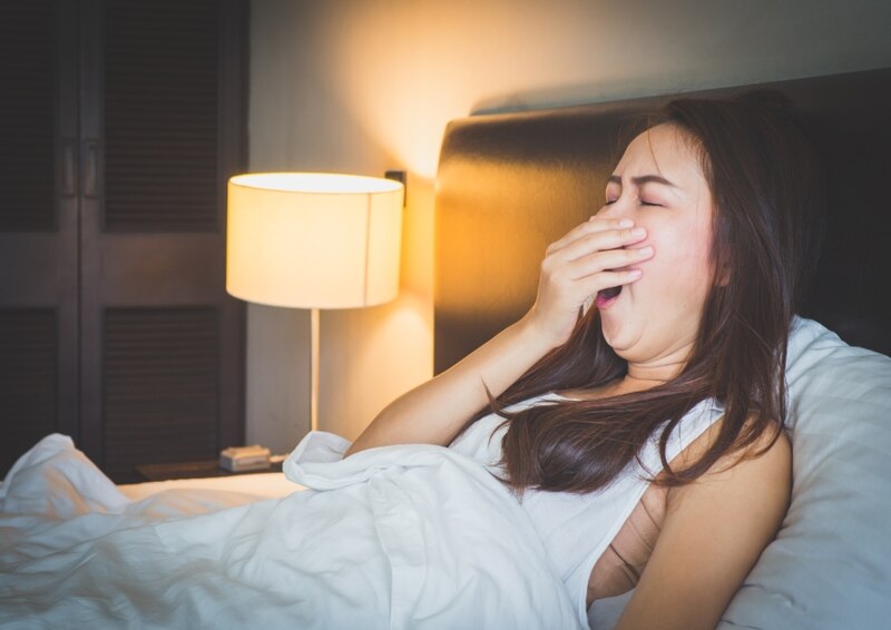 Mujer bostezando en la cama