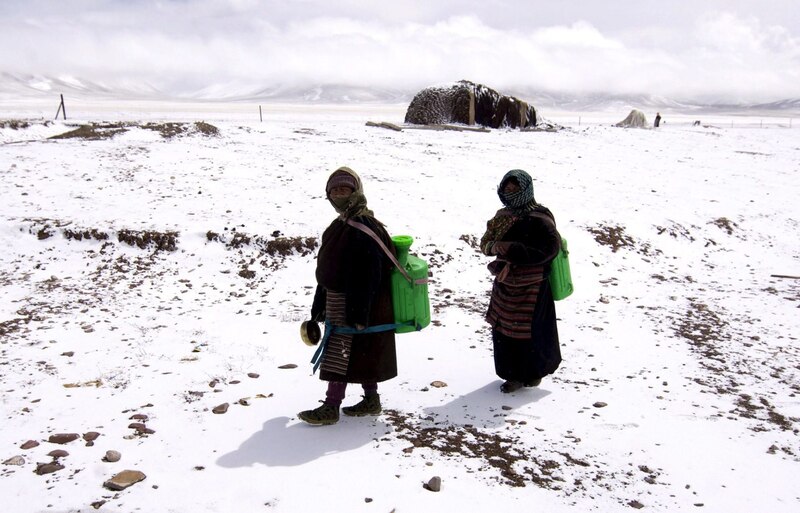 Mujeres tibetanas caminan por la nieve